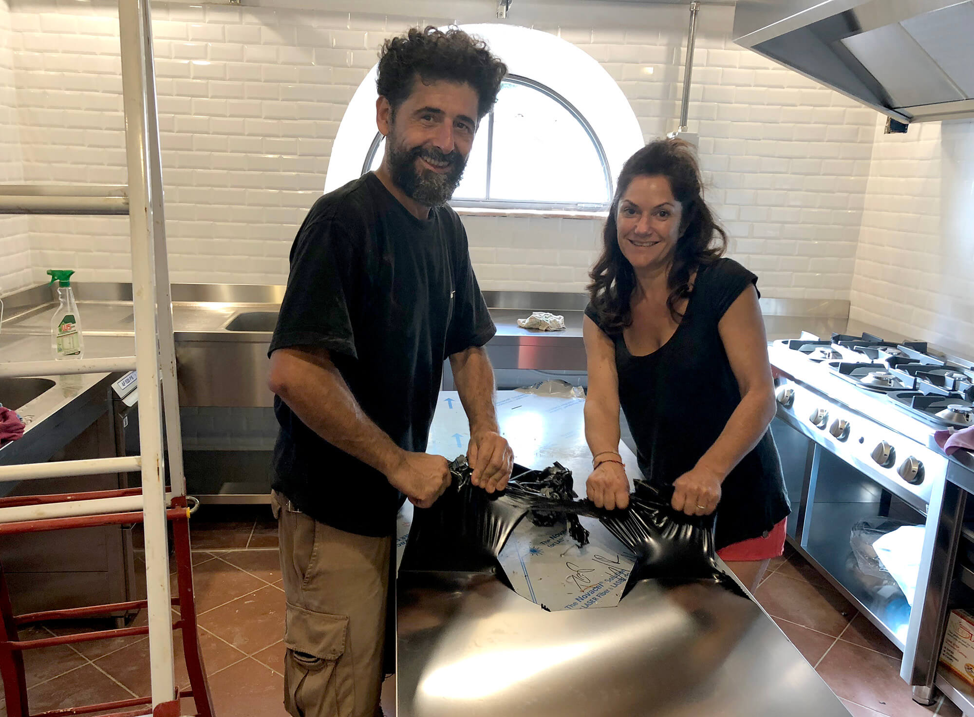 Fabrizio e Katia mentre sballano la cucina industriale della sala colazioni al Podere Camaiano